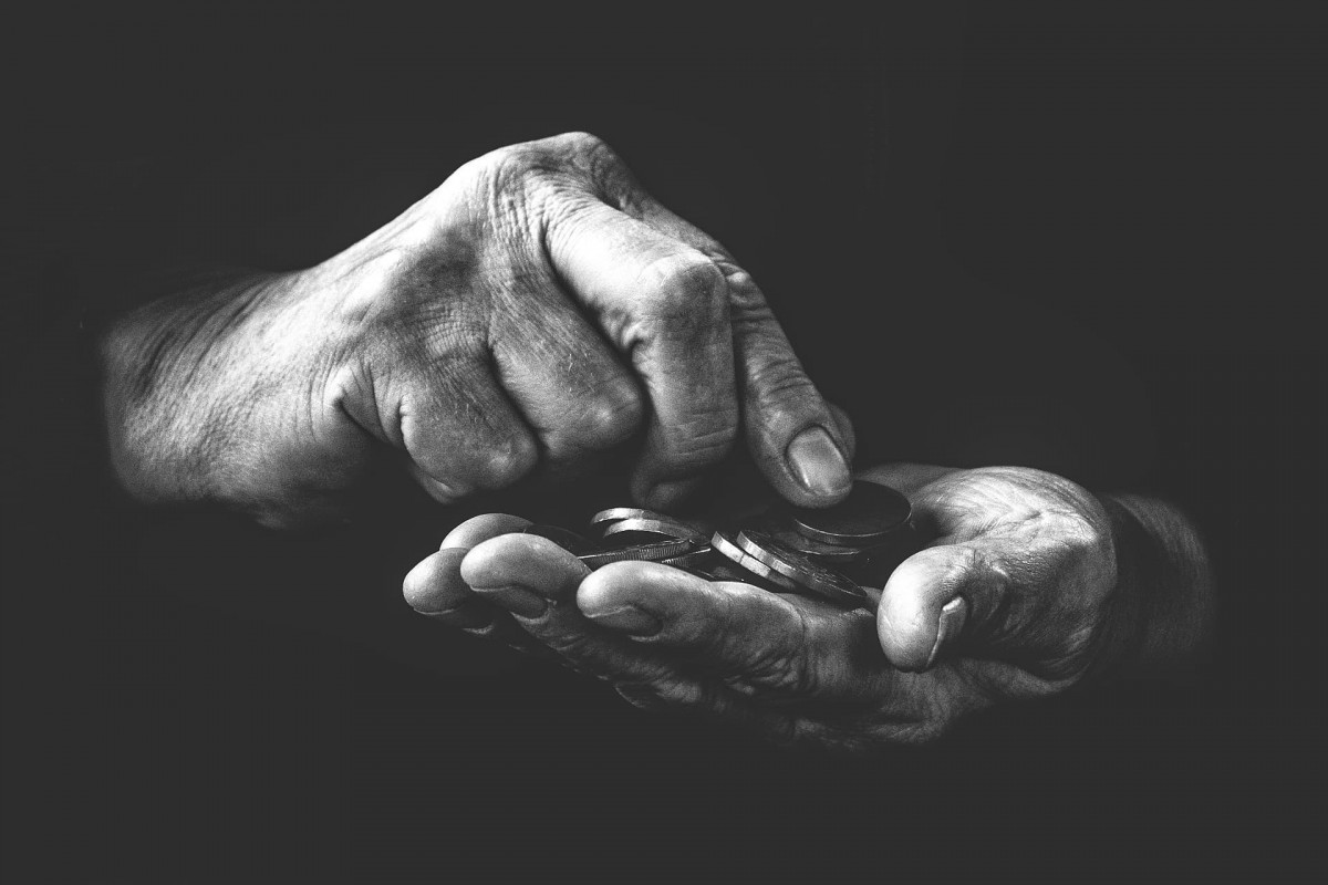 Black and white photo of hands holding coins