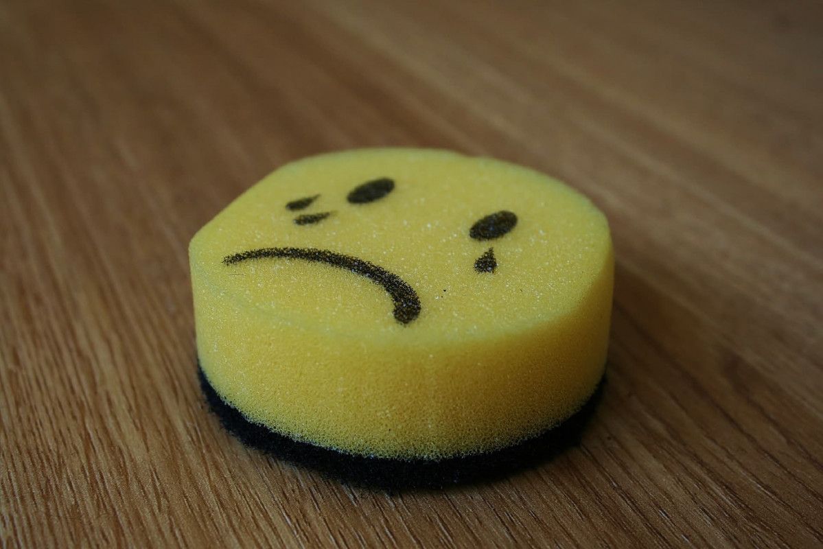Circular sponge with the crying emoji drawn on it