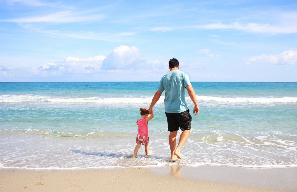 Father and daughter alone on the beach