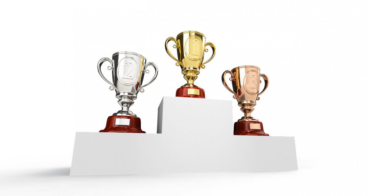 Gold, silver and bronze trophies on a podium