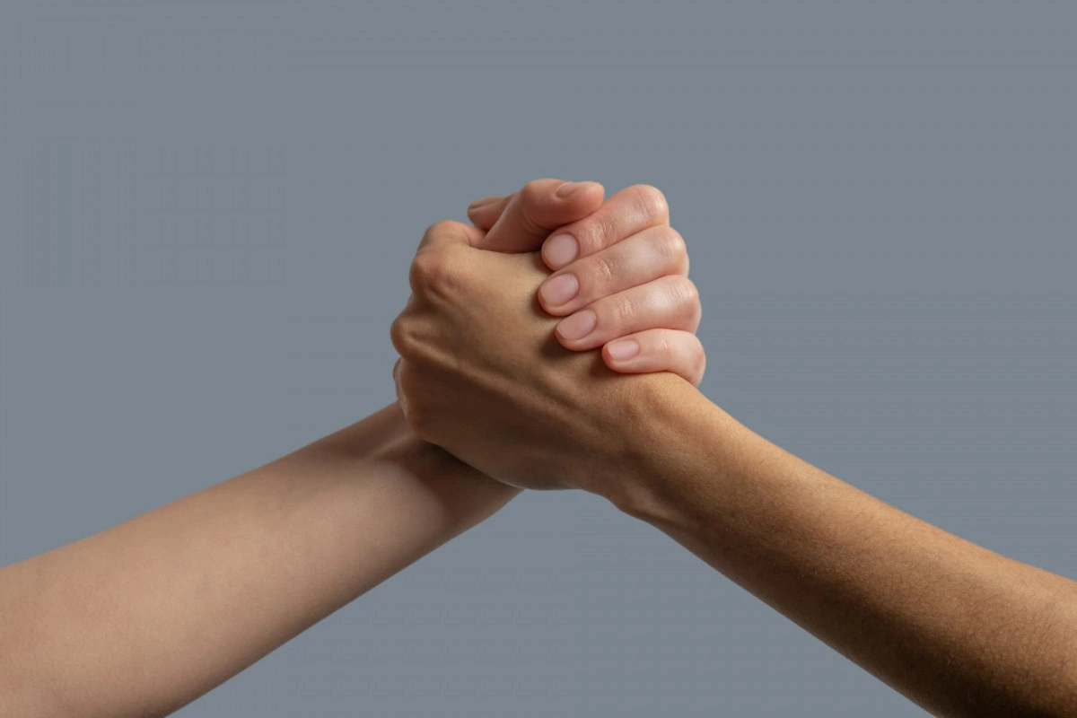 Two hands holding each other as a sign of unity
